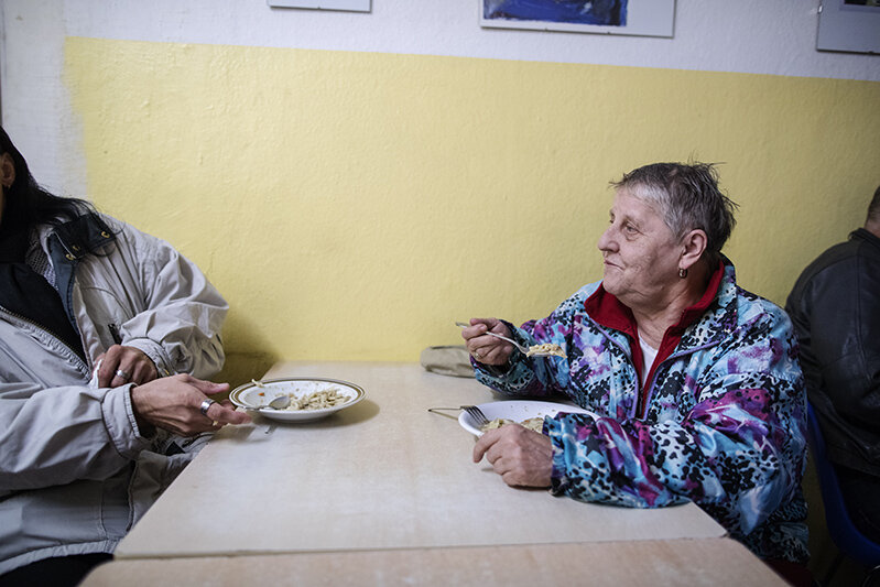 © Diakonie/Hermann Bredehorst zwei obdachlose Frauen sitzen am Tisch und essen eine Suppe