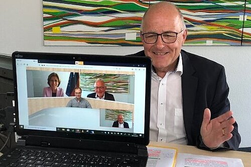 Ein Mann bei einer Vodeoaufzeichnung. Auf einem anderen Bildschoirm ist eine Frau zu sehen.