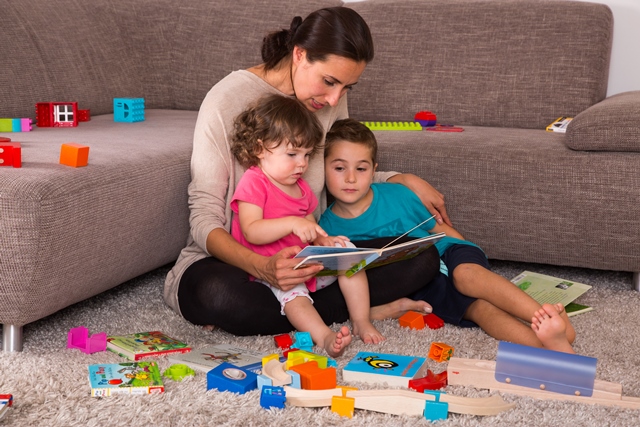 Eine Mutter spielt mit ihren beiden Kindern