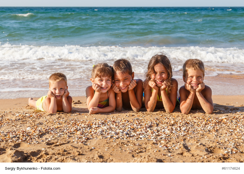 Kinder liegen am Strand